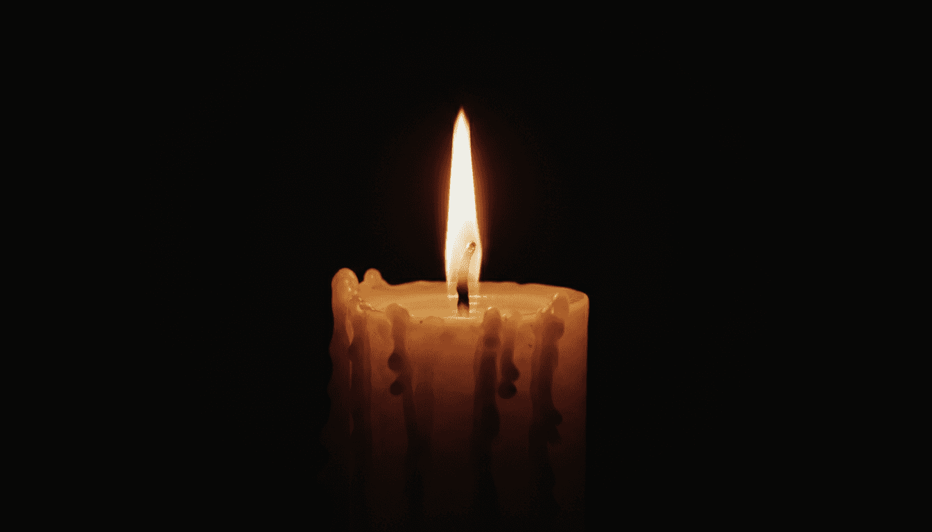 Primer plano de una vela encendida en un entorno oscuro